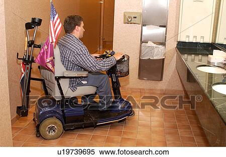 Man with a disability, utilizing a scooter for mobility, entering a restroom hoping to find an accessible stall. View Large Photo Image Stock Photography - Man with a disability, utilizing a scooter for mobility, entering a restroom hoping to find an accessible stall.. Fotosearch