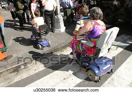 Mother and son crossing a street in New York City, using scooters/carts, while vacationing there. View Large Photo Image Stock Photograph - Mother and son crossing a street in New York City, using scooters/carts, while vacationing there.. Fotosearch