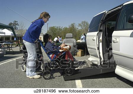 Woman pushes son’s wheelchair up the van ramp (boy with autism) View Large Photo Image Stock Photograph - Woman pushes son’s wheelchair up the van ramp (boy with autism). Fotosearch