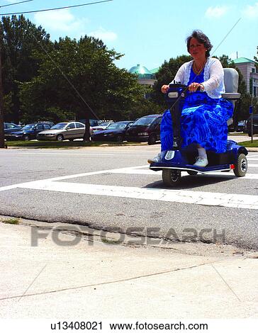 Woman with a disability using a motorized scooter for mobility facing a barrier - no curb cut to allow her to access street. View Large Photo Image Stock Image - Woman with a disability using a motorized scooter for mobility facing a barrier - no curb cut to allow her to access street.. Fotosearch