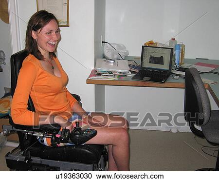 Young woman (electric wheelchair user) laughs as she works in her office. View Large Photo Image Stock Image - Young woman (electric wheelchair user) laughs as she works in her office.. Fotosearch