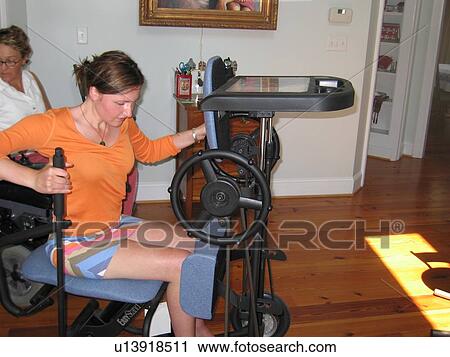 Young woman (muscular dystrophy) prepares to elevate herself on a stander for physical therapy. View Large Photo Image Stock Image - Young woman (muscular dystrophy) prepares to elevate herself on a stander for physical therapy.. Fotosearch