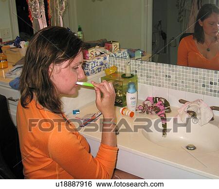 Young woman (wheelchair user) brushes her teeth in an accessible bathroom. View Large Photo Image Stock Photograph - Young woman (wheelchair user) brushes her teeth in an accessible bathroom.. Fotosearch