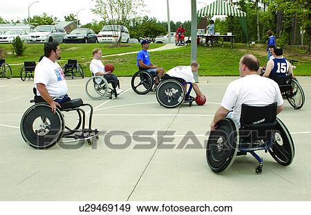 A group of men playing a game of wheelchair basketball at their local recreation center. View Large Photo Image Stock Photo - A group of men playing a game of wheelchair basketball at their local recreation center.. Fotosearch