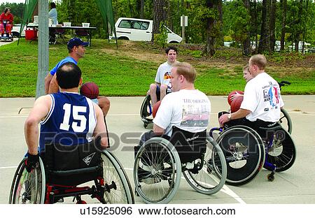 Stock Photograph - A group of men playing a game of wheelchair basketball at their local recreation center.. Fotosearch