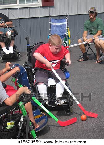 Stock Photo - Boy, in wheelchair, playing hockey.. Fotosearch