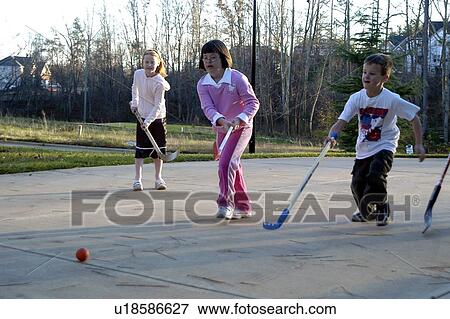 Girl with Down syndrome playing street hockey with a group of children View Large Photo Image Stock Photo - Girl with Down syndrome playing street hockey with a group of children. Fotosearch