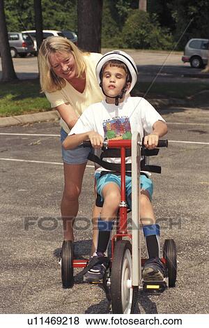 Little boy who is blind and has other disabilities riding an adapted tricycle. View Large Photo Image Stock Photo - Little boy who is blind and has other disabilities riding an adapted tricycle.. Fotosearch