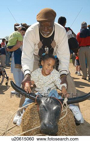 Little girl with multiple disabilities riding a "pretend bull" during a fun day at a petting zoo. View Large Photo Image Stock Image - Little girl with multiple disabilities riding a "pretend bull" during a fun day at a petting zoo.. Fotosearch