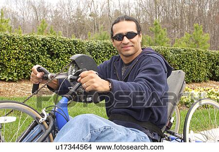 Man with a disability having fun riding his hand-controlled bicycle. View Large Photo Image Picture - Man with a disability having fun riding his hand-controlled bicycle.. Fotosearch