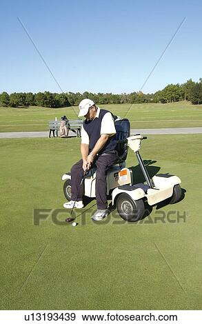 Man with a disability playing golf at a golf course while sitting on his scooter that he uses for mobility. View Large Photo Image Stock Photo - Man with a disability playing golf at a golf course while sitting on his scooter that he uses for mobility.. Fotosearch