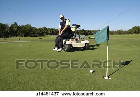 Man with a disability playing golf at a golf course while sitting on his scooter that he uses for mobility. View Large Photo Image Stock Photo - Man with a disability playing golf at a golf course while sitting on his scooter that he uses for mobility.. Fotosearch