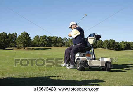 Man with a disability playing golf at a golf course while sitting on his scooter that he uses for mobility. View Large Photo Image Stock Photo - Man with a disability playing golf at a golf course while sitting on his scooter that he uses for mobility.. Fotosearch