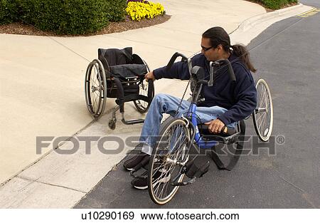 Man with a disability transferring from a hand-controlled bicycle to a wheelchair. View Large Photo Image Stock Photo - Man with a disability transferring from a hand-controlled bicycle to a wheelchair.. Fotosearch