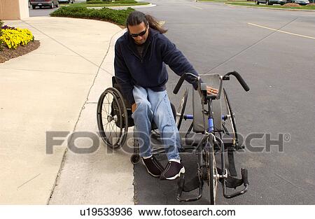 Man with a disability utilizing a wheelchair for mobility transferring into his hand-controlled bicycle. View Large Photo Image Stock Photograph - Man with a disability utilizing a wheelchair for mobility transferring into his hand-controlled bicycle.. Fotosearch