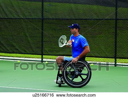 Man with a disability, who utilizes a wheelchair for mobility, playing tennis with a friend at his local recreation center. View Large Photo Image Stock Photograph - Man with a disability, who utilizes a wheelchair for mobility, playing tennis with a friend at his local recreation center.. Fotosearch
