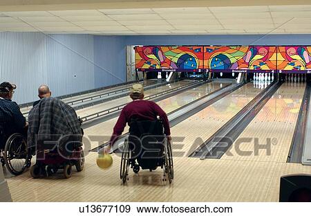 People with disabilities, utilizing wheelchairs for mobility, enjoying an evening bowling at their local bowling alley. View Large Photo Image Stock Photo - People with disabilities, utilizing wheelchairs for mobility, enjoying an evening bowling at their local bowling alley.. Fotosearch