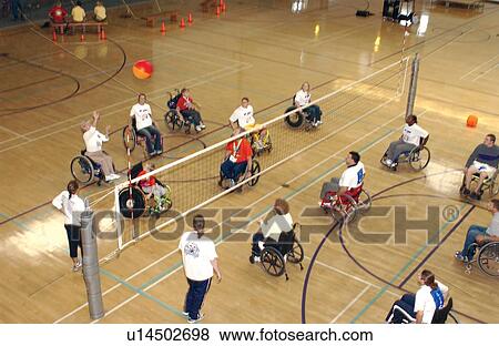 Several people with disabilities playing a game of wheelchair volleyball on an indoor court. View Large Photo Image Stock Photo - Several people with disabilities playing a game of wheelchair volleyball on an indoor court.. Fotosearch