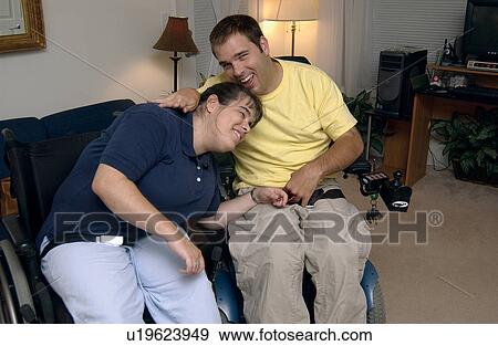 Stock Photo - A young couple, both with disabilities, hugging, holding hands with each other and enjoying being together.. Fotosearch