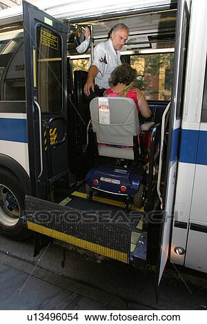 Boy with Muscular Dystrophy, utilizing a scooter/cart for mobility, getting on a city bus via a chair lift. View Large Photo Image Picture - Boy with Muscular Dystrophy, utilizing a scooter/cart for mobility, getting on a city bus via a chair lift.. Fotosearch