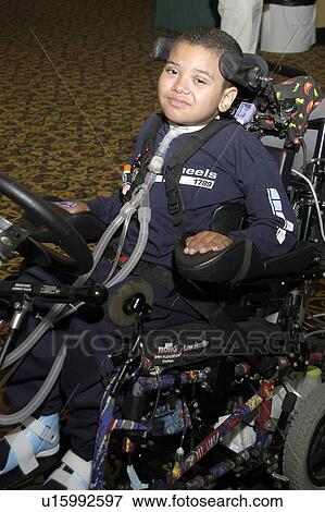 Stock Photo - Little boy with multiple disabilities operating his wheelchair.. Fotosearch
