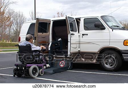 Man utilizing a powered wheelchair using the lift on his accessible van to gain entry. View Large Photo Image Picture - Man utilizing a powered wheelchair using the lift on his accessible van to gain entry.. Fotosearch