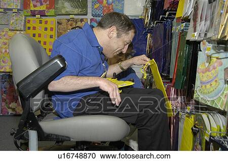 Man with a disability using a wheelchair for mobility, working in a store. View Large Photo Image Stock Image - Man with a disability using a wheelchair for mobility, working in a store.. Fotosearch
