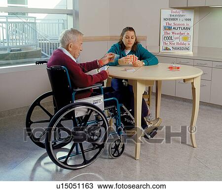 Older man with a disability playing cards with his friend. View Large Photo Image Stock Image - Older man with a disability playing cards with his friend.. Fotosearch