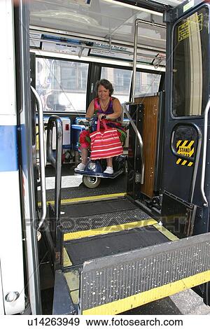 Woman using a scooter/cart for mobility getting off a city bus via a lift. View Large Photo Image Stock Photo - Woman using a scooter/cart for mobility getting off a city bus via a lift.. Fotosearch