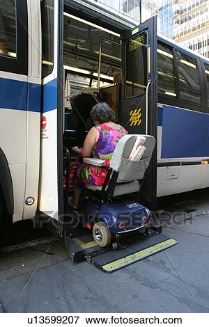 Woman utilizing a scooter/cart using a chair lift to get on a city bus. View Large Photo Image Stock Photo - Woman utilizing a scooter/cart using a chair lift to get on a city bus.. Fotosearch