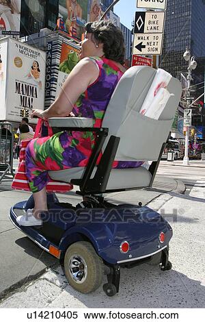 Stock Photography - Woman with muscular dystrophy utilizing a scooter/cart to sight-see in New York City.. Fotosearch