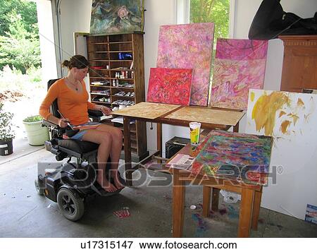 Stock Photo - Young artist (female wheelchair user) enters her studio.. Fotosearch
