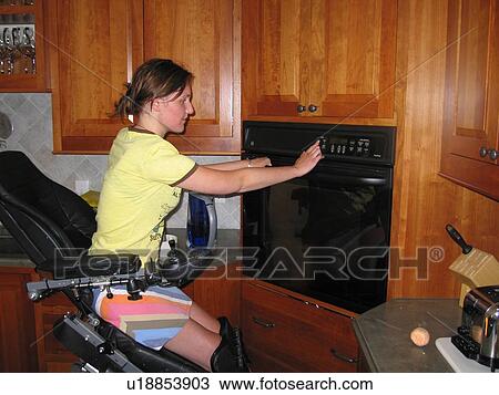 Young woman (electric wheelchair user) sets times on her accessible oven. View Large Photo Image Stock Image - Young woman (electric wheelchair user) sets times on her accessible oven.. Fotosearch