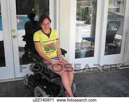 Young woman (electric wheelchair user) smiles at the camera in front of her accessible home. View Large Photo Image Stock Image - Young woman (electric wheelchair user) smiles at the camera in front of her accessible home.. Fotosearch