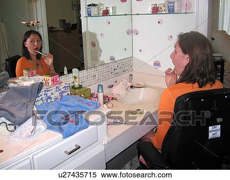 Young woman (wheelchair user) brushes her teeth in her accessible bathroom. View Large Photo Image Stock Photography - Young woman (wheelchair user) brushes her teeth in her accessible bathroom.. Fotosearch
