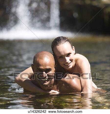 Young couple embracing in a natural pool View Large Photo Image Stock Image - Young couple embracing in a natural pool. Fotosearch