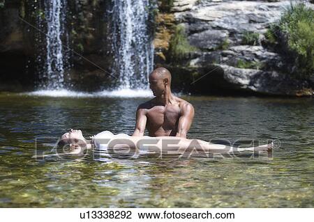 Young couple in a natural pool near a waterfall View Large Photo Image Stock Image - Young couple in a natural pool near a waterfall. Fotosearch