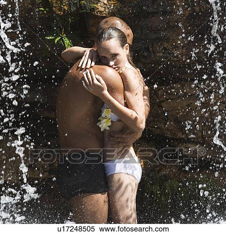 Young couple standing in a waterfall, embracing View Large Photo Image Stock Photography - Young couple standing in a waterfall, embracing. Fotosearch