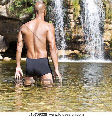 Young man in a natural pool with waterfall View Large Photo Image Stock Photography - Young man in a natural pool with waterfall. Fotosearch