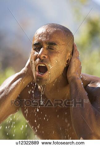 Young man splashing water on face, close-up View Large Photo Image Stock Photo - Young man splashing water on face, close-up. Fotosearch
