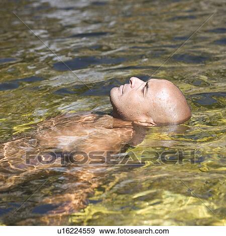 Young man swimming in a natural pool, close-up View Large Photo Image Stock Photo - Young man swimming in a natural pool, close-up. Fotosearch