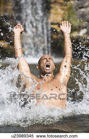 Young man swimming in a natural pool View Large Photo Image Stock Photography - Young man swimming in a natural pool. Fotosearch