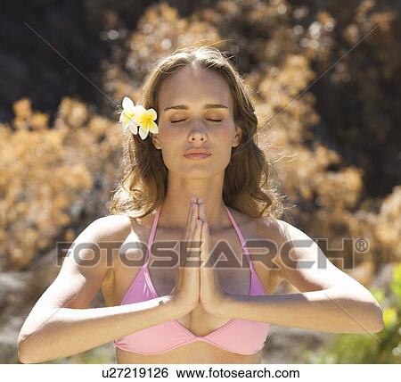 Young woman in a bikini practicing yoga View Large Photo Image Stock Photograph - Young woman in a bikini practicing yoga. Fotosearch