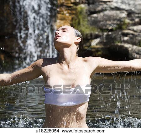Picture - Young woman standing in a natural pool. Fotosearch