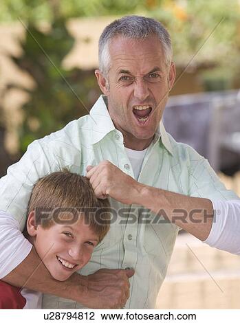 Stock Image - A father with his young son fooling about. Fotosearch