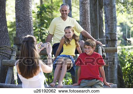 A mother taking a photograph of her husband and children View Large Photo Image Stock Image - A mother taking a photograph of her husband and children. Fotosearch