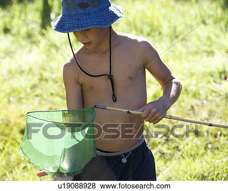 A young boy holding a fishing net View Large Photo Image Stock Photo - A young boy holding a fishing net. Fotosearch