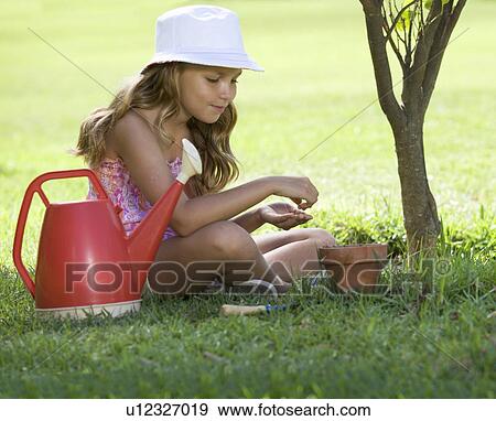 A young girl planting seeds in a plant pot View Large Photo Image Stock Photo - A young girl planting seeds in a plant pot. Fotosearch