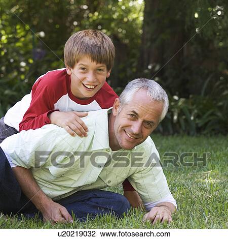 Father and son playing in a garden View Large Photo Image Stock Image - Father and son playing in a garden. Fotosearch