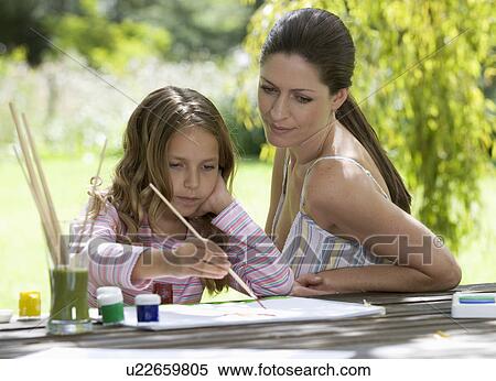 Mother and young daughter sitting in a garden painting View Large Photo Image Stock Photography - Mother and young daughter sitting in a garden painting. Fotosearch